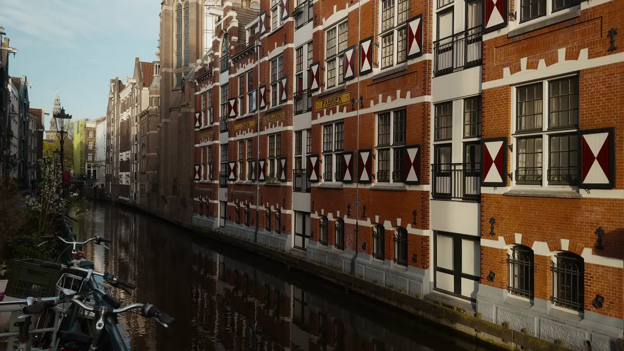 Canal houses with red and white shutters along a quiet Amsterdam canal (Land Registry and property)